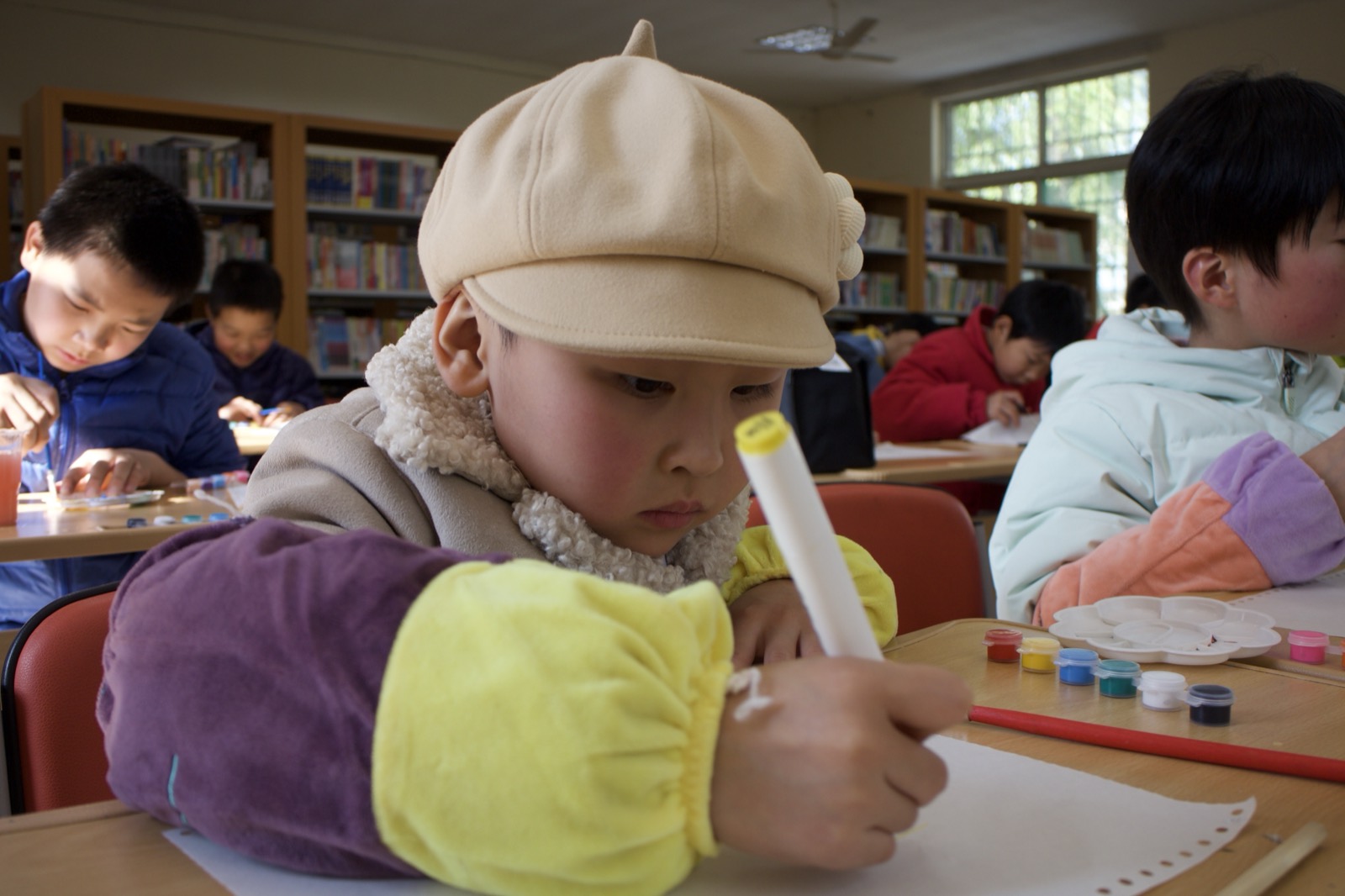 A child concentrating on a drawing in class