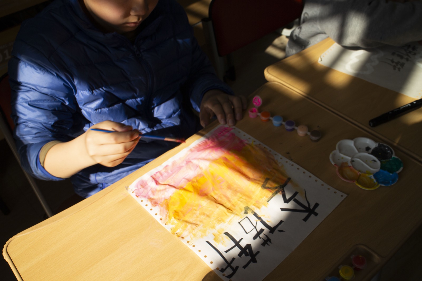 A child painting in warm afternoon light